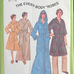 May include: A Simplicity 8275 sewing pattern envelope for The Every-Body Robes, featuring illustrations of four robe styles in yellow, beige, blue, and a dark plaid pattern. The text includes Small, Everybody Chest or Bust 32"-34".