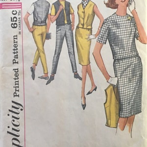 May include: Simplicity Printed Pattern 65c, a vintage sewing pattern for a junior size 11 dress with a 31 1/2 inch bust. The pattern shows three different styles of the dress, one with a skirt and two with pants.