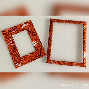 May include: Two orange and white patterned picture frames. The frames are made of cardboard and have a simple design.
