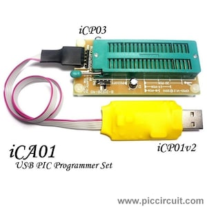 Pode incluir: Um conjunto de programador USB PIC amarelo com uma placa de circuito verde e um cabo preto. A placa de circuito tem o texto "iCP03-MULTI PIC ADAPTER WWW.PICCIRCUIT.COM" e "iCP03-V12 ©2010". O conjunto é etiquetado como "iCA01 USB PIC Programmer Set" e "iCP01v2".