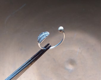 Justerbar ring med fjäder i 9 karat guld och silver