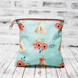 May include: A turquoise zippered pouch with a red zipper and a silver clip. The pouch has a pattern of red flowers, teepees, and white triangles. The pouch has the text "Perfectly Imperfect" printed on the side.