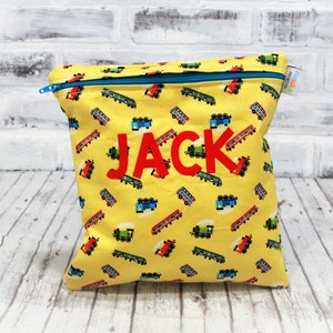 May include: Yellow zippered pouch with a red train pattern and the name "JACK" embroidered in red letters.