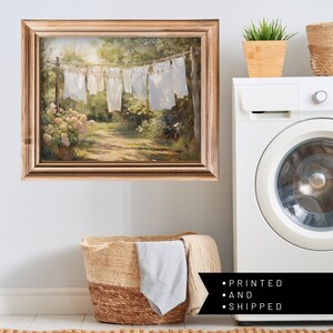 Charming laundry room art: Sheets on clothesline amid floral landscape, a modern print capturing serene spring scenery.