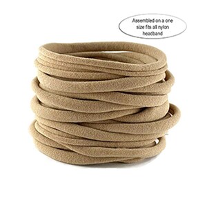 Puede incluir: Una pila de diademas de nailon color beige. Las diademas son redondas y parecen estar hechas de un material suave y el&aacute;stico. El texto de la imagen dice: "Assembled on a one size fits all nylon headband."