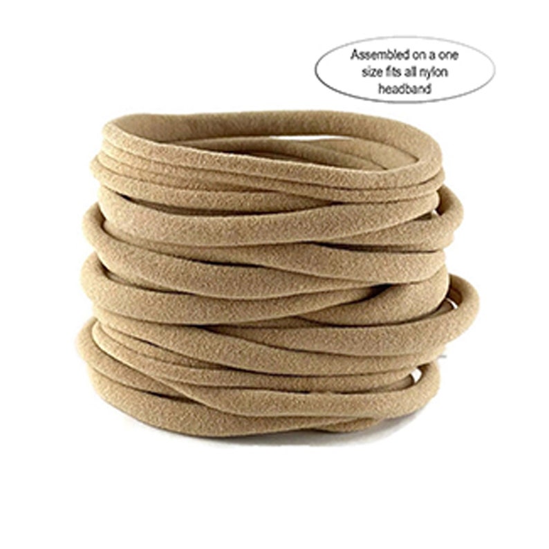 Puede incluir: Una pila de diademas de nailon color beige. Las diademas son redondas y parecen estar hechas de un material suave y el&aacute;stico. El texto de la imagen dice: "Assembled on a one size fits all nylon headband."
