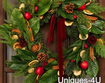 Magnolia leaves wreath with apples, pinecones, cinnamon sticks and dried orange slices.