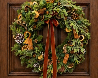 Green Pine Wreath with cinnamon sticks, dried Orange, lemon and apples. Bow