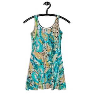 Puede incluir: Un vestido sin mangas con un estampado abstracto en azul verdoso, dorado y negro. El vestido tiene un escote redondo y un corpiño ajustado. La falda es acampanada y llega hasta la rodilla.