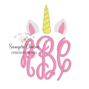 Puede incluir: Letras de monograma rosa "B" y "E" con un cuerno de unicornio amarillo y dos orejas de unicornio blancas con el interior rosa. El texto "Sawyers Charm Embroidery Designs" está debajo del monograma.
