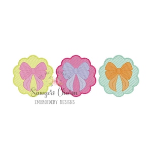 May include: Three embroidered designs of bows in different colors. The bows are pink, purple, and orange. Each bow is on a scalloped circle with a different color background. The background colors are yellow, pink, and green.