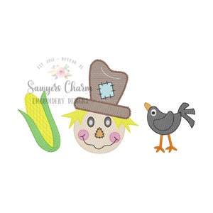 May include: Embroidered design featuring a scarecrow with a brown hat, a yellow face, and a stitched smile. A small black bird with orange legs is to the right of the scarecrow. A green corn stalk is to the left of the scarecrow. The text "Sawyers Charm Embroidery Designs" is below the scarecrow.