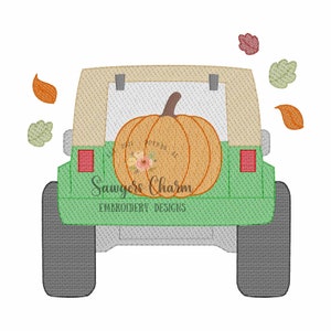May include: A green Jeep with a tan top and a large orange pumpkin in the back. There are several small brown and green leaves scattered around the Jeep.