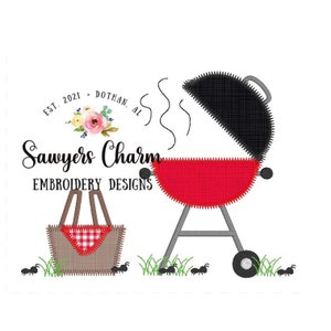 Op de afbeelding: Borduurontwerp met een rode en zwarte barbecue met rook die uit de bovenkant komt, een picknickmand met een rood-wit geruite doek en mieren op de grond. De tekst "Sawyers Charm Embroidery Designs" staat boven de barbecue. De tekst "Est. 2021 - Dothan, AL" staat boven de tekst "Sawyers Charm".