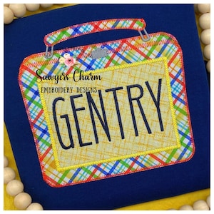 Könnte beinhalten: Eine gelbe und rote karierte Stoffapplikation in Form eines Vintage-Radios mit dem Text "Sawyers Charm Embroidery Designs" und dem Namen "GENTRY" in Schwarz.