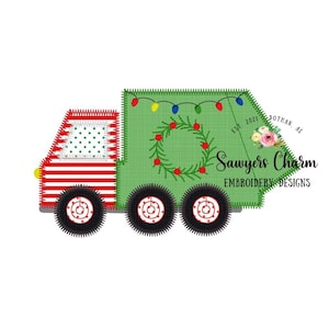 May include: A green Christmas tree-shaped garbage truck with red and white stripes, a wreath, and lights. The truck has the text "Sawyers Charm Embroidery Designs" and "Est. 2021 Dothan, AL" on the side.