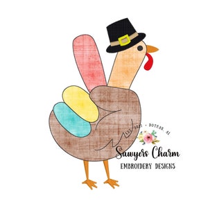 May include: A brown turkey with a peace sign made of colourful feathers, wearing a black pilgrim hat with a gold buckle. The turkey is standing on a white background with the text "Sawyers Charm Embroidery Designs" below it.