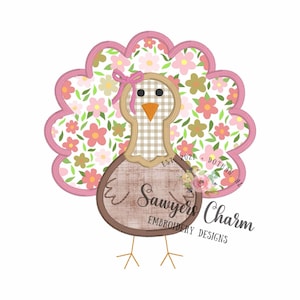 May include: A decorative turkey design featuring a floral patterned tail in shades of pink, white, and green. The turkey has a brown body with a wooden sign that reads "Sawyers Charm Embroidery Designs". A pink bow is tied on the turkey's head. Ideal for autumn and Thanksgiving.