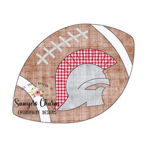 May include: A brown football with white stitching and a white stripe. The football has a red and white checkered background with a gray Spartan helmet in the center. The text "Sawyers Charm Embroidery Designs" is on the bottom left of the football.