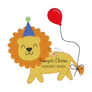 May include: A yellow lion wearing a blue party hat and holding a red balloon. The lion is smiling and has a happy expression. The text "Sawyers Charm Embroidery Designs" is below the lion.