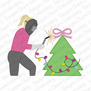May include: An embroidered design featuring a person welding a spark onto a green Christmas tree. The person is wearing a welding mask, gloves, and a pink shirt. The tree is decorated with a pink bow and colorful lights.