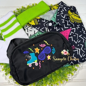 May include: A collection of 80s-themed accessories, including a black fanny pack with embroidered roller skates and sunglasses, a neon green headband, white socks with green stripes, and a button-down shirt with a geometric pattern. The fanny pack has the text "Sawyers Charm".