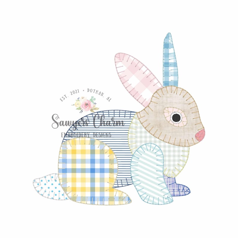 Peut inclure: Un motif de lapin patchwork aux couleurs pastel. Le lapin pr&eacute;sente une oreille rose &agrave; carreaux, une section &agrave; carreaux bleu et jaune et une section &agrave; rayures. Le motif comprend le texte "Sawyers Charm Embroidery Designs".
