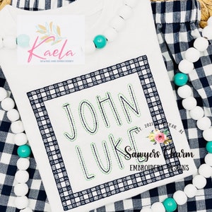 Puede incluir: Unisie blanco con un borde a cuadros blanco y negro alrededor del texto "JOHN LUKE" con el texto "EST. 2021" y "Sawyers Charm EMBROIDERY DESIGNS" debajo.