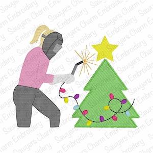 May include: An embroidered design featuring a person welding a Christmas tree. The person is wearing a welding mask, gloves, and a pink shirt. The tree is green with a yellow star and colorful lights. The design has a festive theme.
