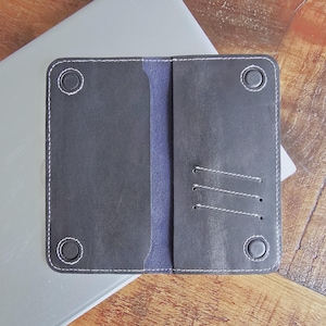 May include: A handmade wooden sign displaying the word "Welcome" in a handwritten font. The sign is painted white with a distressed finish, and a small green leaf is attached. Suitable for indoor or outdoor use.