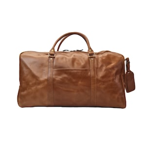 May include: A brown leather duffel bag with brass hardware and a luggage tag.