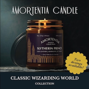 May include: A brown glass candle jar with a gold lid. The label reads "Amortentia Malfoy Collection Slytherin Prince Old Leather | Ashwood | Icy Wind Harry Potter by J.K. Rowling". The candle is lit and the flame is visible. The text "Two designs available!" is in a yellow circle.