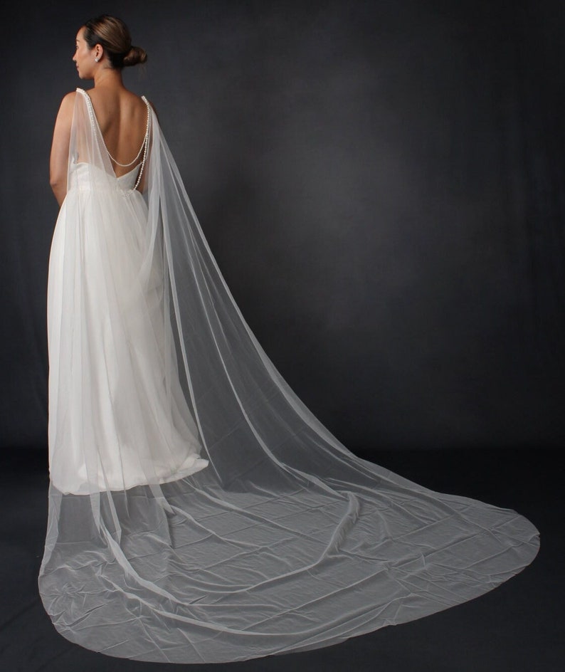 Wedding dress cape with bridal pearl shawl
Elegant bolero with long wedding dress cover-up
Wedding drape veil with pearls for bride
Bridal capelet with pearl shawl for gowns
Pearl wedding cape for elegant brides
Long bridal bolero