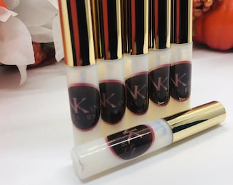 May include: Six gold and white bottles of lash adhesive with the text "KK Lashes" on the label.