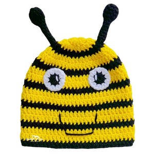 Può includere: Un cappello all'uncinetto a righe gialle e nere con un motivo a forma di ape. Il cappello presenta occhi bianchi, un sorriso nero e due antenne nere. Questo cappello fatto a mano è adatto per un costume per bambini o per l'uso quotidiano.