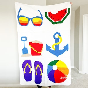 May include: White blanket featuring colorful pixelated summer icons: sunglasses, watermelon slice, sand pail, anchor, flip-flops, and a beach ball. The blanket is a cozy, handmade item with a beach theme.