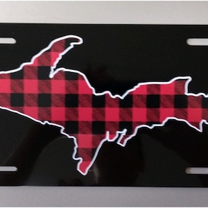 May include: Black metal license plate with a white outline of the Upper Peninsula of Michigan filled with a red and black plaid pattern.