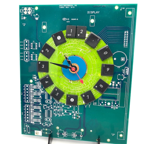 Reverse Time clock- runs and reads counter clock-wise, keyboard numerals on cd over unpopulated circuit bd, wall or desk