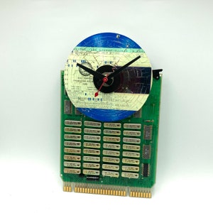 May include: A clock made from a circuit board and a blue vinyl record with a white and black design. The clock face is a white and black engineering document with the text "Dual Purpose Engineering Document Card".
