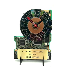May include: A clock made from a computer hard drive with a gold plaque that reads "Congratulations on your Graduation".
