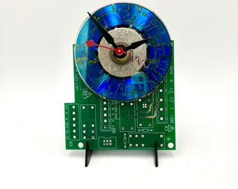Blue altered mini CD on  unpopulated circuit board clock, easel stand & AA  included.