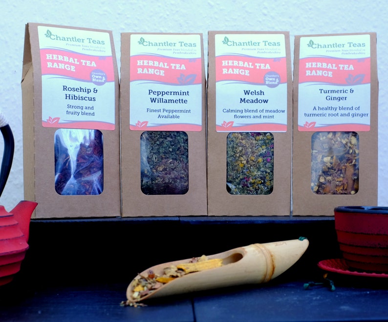 Pu&ograve; includere: Quattro scatole di cartone marrone con finestre di plastica trasparente che mostrano diverse miscele di tisane. Le scatole sono etichettate "Chantler Teas Herbal Tea Range" e elencano i sapori del t&egrave;: Rosa canina e ibisco, Menta Willamette, Prato gallese e Curcuma e zenzero.