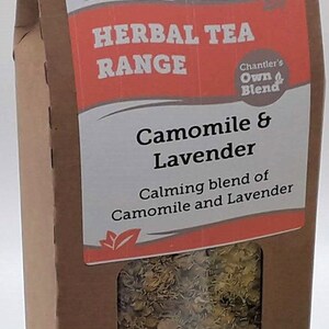 Puede incluir: Una caja de cart&oacute;n marr&oacute;n con una ventana que muestra una mezcla de flores secas de manzanilla y lavanda. La caja est&aacute; etiquetada "Chantler Teas Herbal Tea Range Camomile & Lavender Calming blend of Camomile and Lavender".