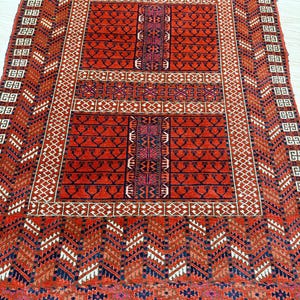 May include: A red, blue, and white patterned rug with intricate geometric designs. The rug has a central medallion with a border of smaller geometric shapes.