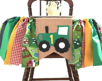 May include: Green and yellow fabric banner with a green tractor with the number 1 on it. The banner is decorated with farm animals and a red barn.