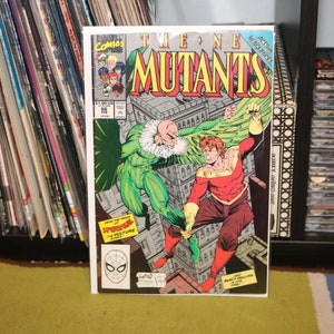 May include: A comic book cover featuring a green and brown character with wings flying towards a red and gold character. The comic book is titled "The New Mutants" and the issue number is 86.