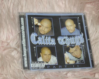 May include: A CD case with a black background and a white title that reads "CaliFa Thugz Part II". The cover features four men with their names listed below their images. The website address "www.lowprofilerecords.com" is printed on the left side of the case.