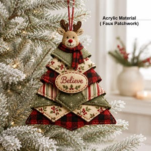 May include: A Christmas tree-shaped ornament made of acrylic material with a faux patchwork design. The ornament features a reindeer head at the top wearing a red and black plaid scarf, and an oval patch in the center with the word Believe.