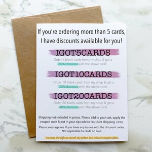 May include: A white card with pink and blue brushstrokes. The card lists discounts for ordering multiple blank cards. The discounts are 20%, 30%, and 40% for orders of 5, 10, and 20 cards, respectively. The discount codes are IGOT5CARDS, IGOT10CARDS, and IGOT20CARDS.