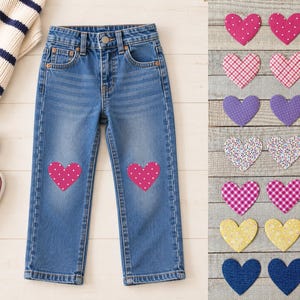 May include: Blue denim jeans featuring two pink heart-shaped patches with white polka dots on the knees. To the right, seven pairs of heart-shaped fabric patches are displayed in various colors and patterns, including polka dots, gingham, and solid blue.